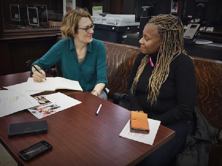 Photo of Ame looking at papers with a research participant.